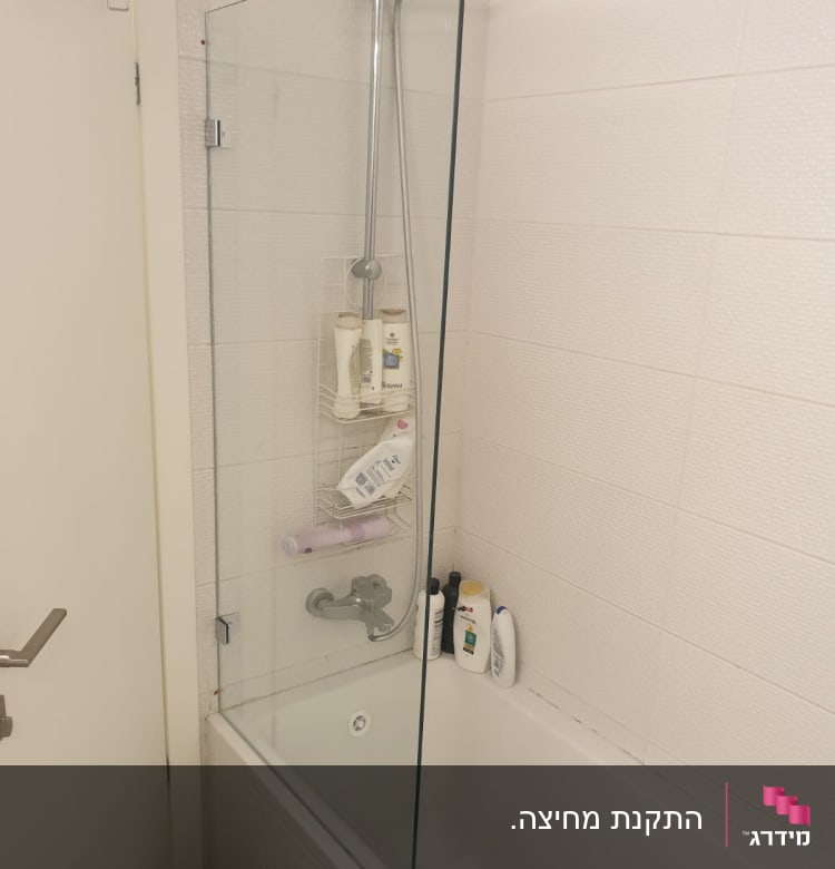 מחיצת זכוכית במקלחת עם ברז ומוצרים